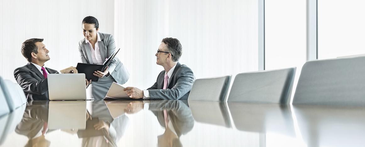 Two men and one woman meeting in a conference room
