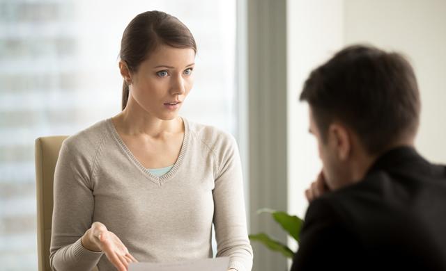 woman holding contract disagreeing with man